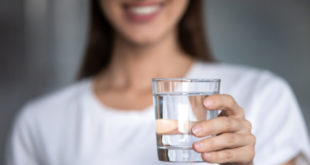 žena držiaca pohár vody